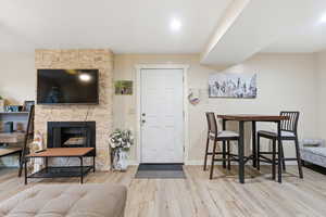Living area featuring a stone fireplace and light wood-type flooring