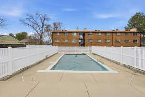 Community pool featuring a fenced backyard and a patio