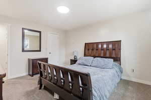 Bedroom featuring light carpet and baseboards