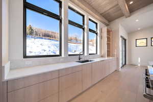 Kitchen featuring modern cabinets, light brown cabinetry, light wood-style flooring, open shelves, and recessed lighting