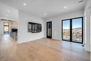 Unfurnished room with light wood finished floors, a fireplace, and recessed lighting