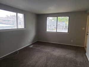 Carpeted empty room featuring baseboards