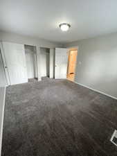 Unfurnished bedroom with two closets and carpet flooring