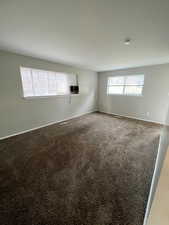 Empty room with carpet flooring and baseboards