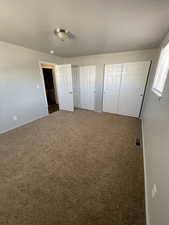 Unfurnished bedroom with two closets and carpet floors