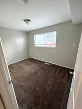 Empty room featuring carpet flooring and a smoke detector