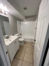 Full bathroom featuring vanity, light tile patterned floors, and  shower combination