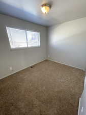 Carpeted empty room featuring baseboards