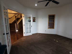 Unfurnished room featuring built in features, french doors, stairs, recessed lighting, and dark colored carpet