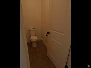 Bathroom featuring dark tile patterned floors and baseboards