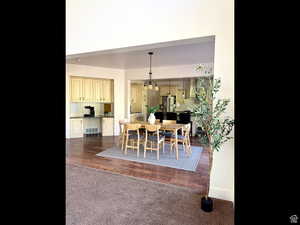 Dining space featuring a chandelier, dark colored carpet, and dark wood-style floors