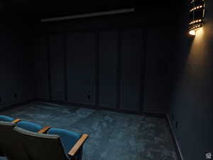 Basement with baseboards and dark carpet