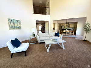 Carpeted living room featuring baseboards and a high ceiling