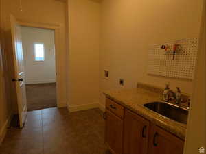 Washroom featuring washer hookup, cabinet space, electric dryer hookup, and dark tile patterned floors