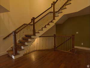 Staircase with a high ceiling and wood-type flooring