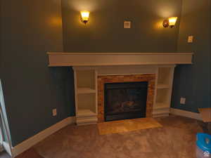 Detailed view of a fireplace with flush hearth and carpet floors