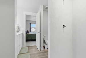 Full bathroom featuring vanity, ensuite bathroom, and light wood-type flooring