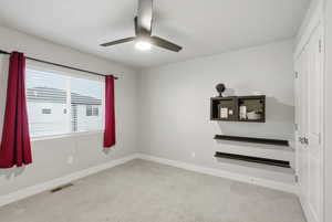 Spare room with light colored carpet and ceiling fan