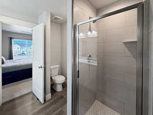 Bathroom featuring a shower stall, light wood-type flooring, and connected bathroom
