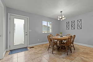 Large dining and kitchen area with island and tile flooring.