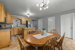 Large dining and kitchen area with island and tile flooring.