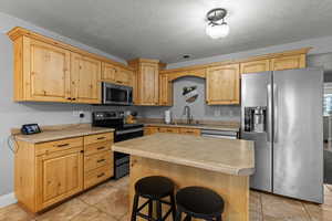 Large dining and kitchen area with island and tile flooring.