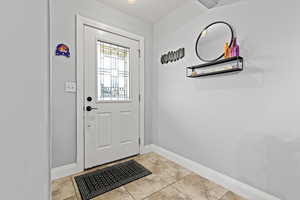 Front entry with tile flooring and lighted door.