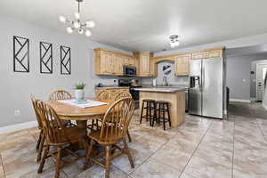 Large dining and kitchen area with island and tile flooring.