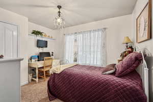 Carpeted bedroom with a chandelier