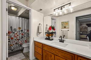 Full bathroom with vanity, a shower, a textured ceiling, and dark wood-style flooring