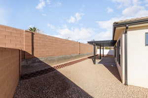 Fenced backyard with a pergola and a patio area