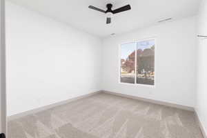 Spare room with light carpet and ceiling fan