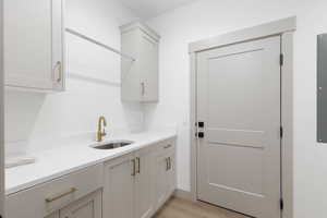 Laundry room with a sink and light wood-style floors