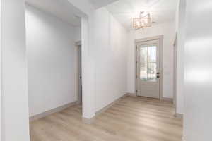 Foyer with a chandelier and light wood-style flooring