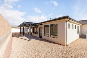 Rear view of property with a pergola, a fenced backyard, stucco siding, and a patio