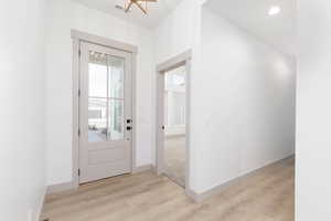 Entrance foyer featuring light wood-type flooring and a chandelier