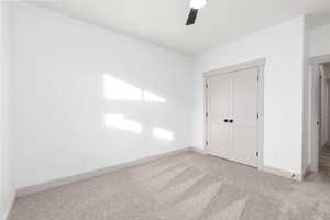 Unfurnished bedroom featuring a closet, carpet floors, and a ceiling fan