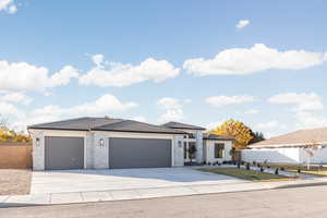 View of front facade featuring concrete driveway, an attached garage, a tile roof, and brick siding