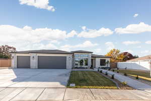 Prairie-style home with concrete driveway, brick siding, and an attached garage