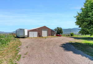 View of outbuilding with driveway, a mountain view, and a rural view
