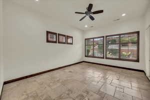 Empty room with stone tile flooring, ceiling fan, and recessed lighting
