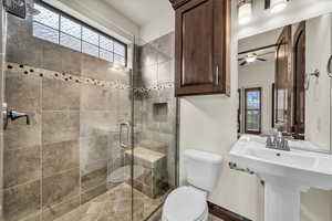 Bathroom featuring a stall shower and ceiling fan