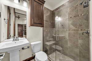 Bathroom featuring a stall shower and a ceiling fan