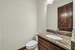 Half bathroom featuring vanity and baseboards