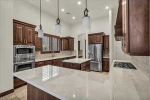Kitchen with tasteful backsplash, recessed lighting, pendant lighting, stainless steel appliances, and a peninsula