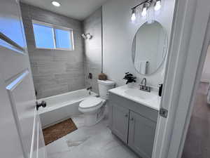 Full bath with vanity, shower / bath combination, and light marble finish floors