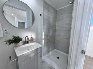 Bathroom featuring a shower stall, vanity, and light marble finish floors