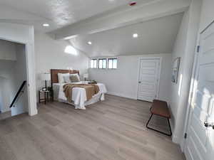 Bedroom with a textured ceiling, light wood-style floors, and recessed lighting