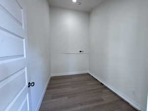 Empty room with dark wood-style floors and baseboards