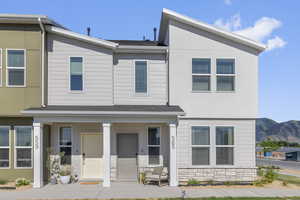 View of front of home featuring covered porch and stone siding